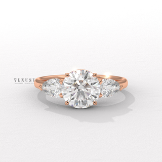 round diamond pear side ring
round diamond engagement ring
pear side stone engagement ring
round center pear side stones
three stone diamond ring
round and pear diamond ring