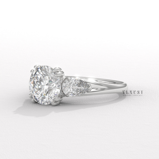 round cut three stone ring
round diamond three stone ring
pear side stone ring
round and pear diamond ring